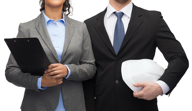 concetto di business, architettura e sviluppo - imprenditrice e uomo d'affari con appunti e casco bianco