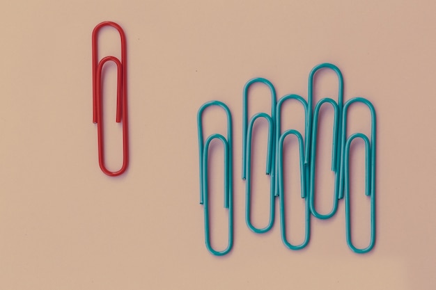 Concetto di business come un gruppo di paperclip su sfondo rosa pastello