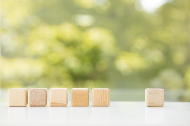 Concetto di business Cubo di legno galleggiante reale geometrico astratto su sfondo verde estivo