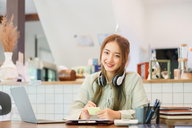 Concetto di business Donna imprenditrice che scrive idea in post-it mentre lavora nello spazio di coworking