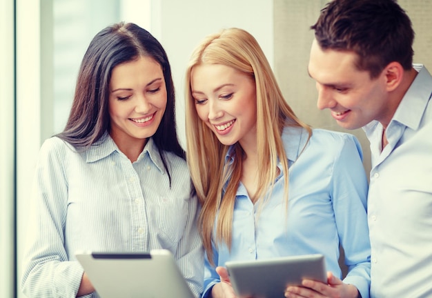 concetto di business e ufficio - team di lavoro sorridente che lavora con tablet pc in ufficio