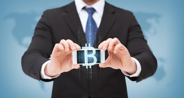 concetto di business, internet, denaro e tecnologia - uomo d'affari che mostra smartphone con bitcoin sullo schermo