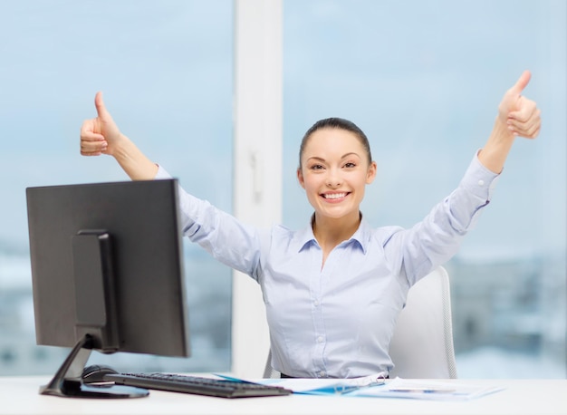 concetto di business, internet, ufficio e tecnologia - donna d'affari sorridente con computer e carta che mostra i pollici in su