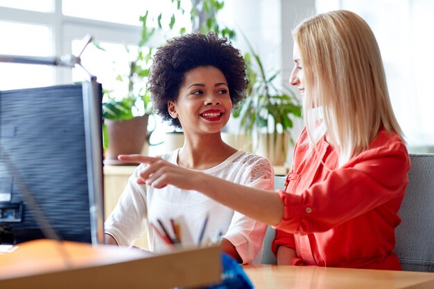 concetto di business, istruzione, avvio e persone - donne o studenti felici con il computer in ufficio