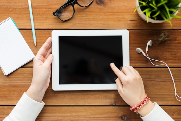 concetto di business, istruzione, tecnologia, persone e pubblicità - primo piano della donna con lo schermo del computer pc tablet vuoto sul tavolo di legno