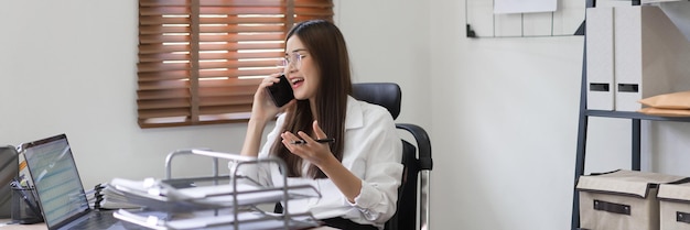 Concetto di business La donna d'affari sta parlando di dati finanziari con il partner sullo smartphone in ufficio