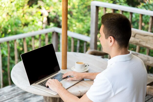 concetto di business, persone e tecnologia - primo piano di uomo d'affari con laptop che lavora all'aperto sulla terrazza estiva e beve caffè