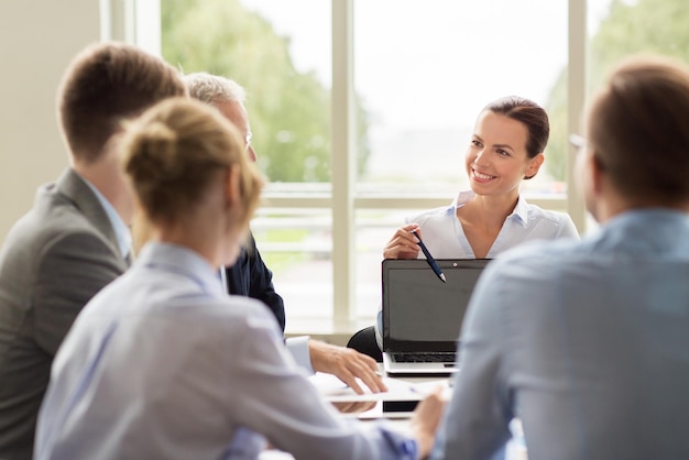 concetto di business, persone e tecnologia - team aziendale con computer portatile che si incontra in ufficio