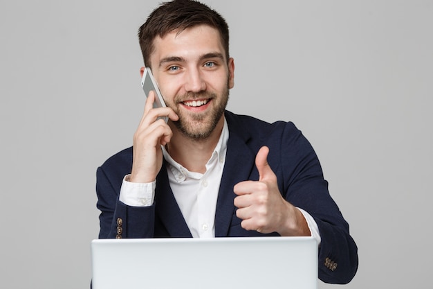 Concetto di Business - Ritratto Bello uomo d&#39;affari mostrando tromba e sorridente faccia fiducioso davanti al suo computer portatile. Sfondo Bianco.