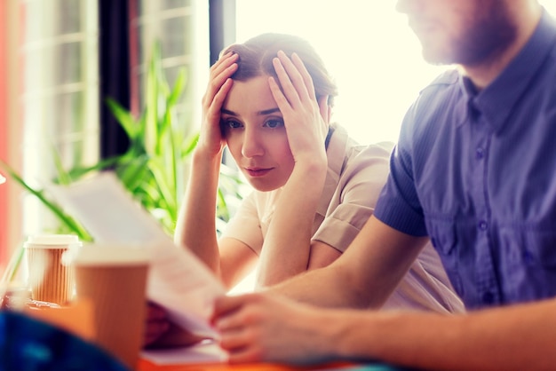 concetto di business, startup e persone - team creativo di uomo e donna con computer e file che risolvono problemi in ufficio