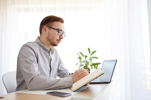 concetto di business, startup e persone - uomo d'affari o lavoratore maschio creativo che scrive su taccuino o diario con penna in ufficio a casa