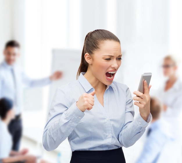 concetto di business, tecnologia e istruzione - donna d'affari urlante con smartphone in ufficio