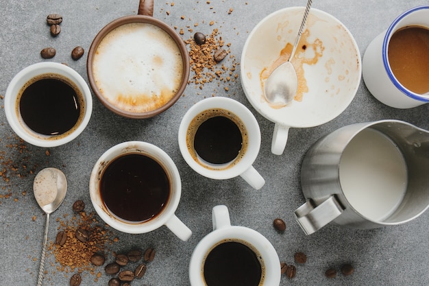 Concetto di caffè con diversi tipi di caffè e oggetti di scena per la preparazione del caffè sul tavolo grigio. Vista dall'alto.