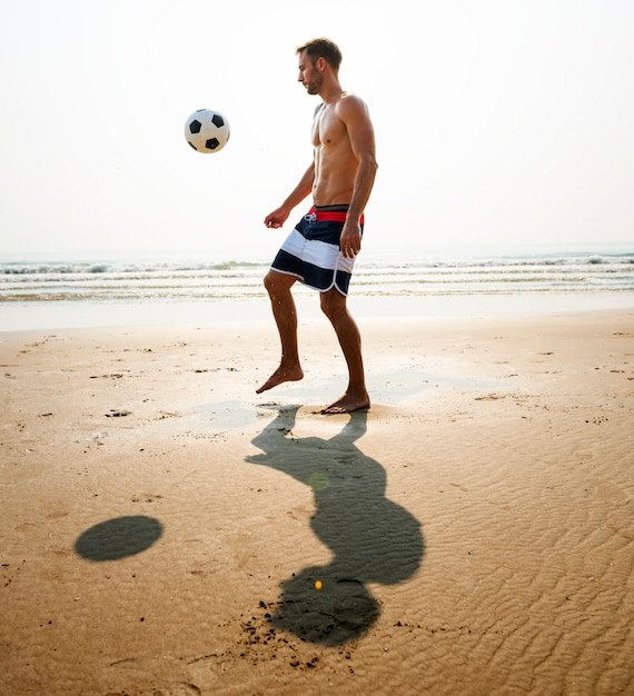 Concetto di calcio di vacanza di vacanza estiva della spiaggia dell&#39;uomo