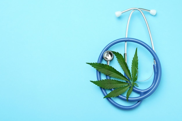 Concetto di cannabis medicinale su sfondo blu, spazio per il testo