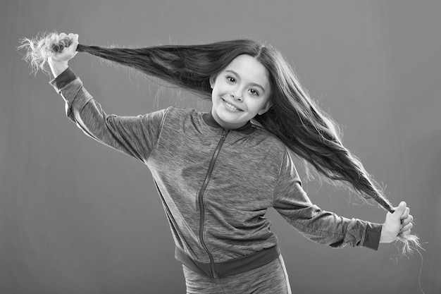 Concetto di capelli forti Ragazza capretto capelli lunghi sani e lucenti La cosa principale è tenerli puliti Usa shampoo delicato e acqua tiepida La bambina cresce i capelli lunghi Insegnare ai bambini abitudini di cura dei capelli sane