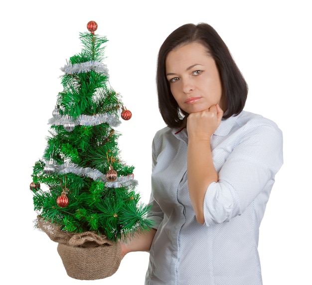 Concetto di Capodanno. Bella donna sogna con albero di Natale decorato su sfondo bianco