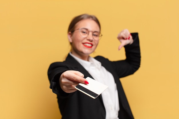 Concetto di carta di credito di espressione orgogliosa di giovane donna graziosa