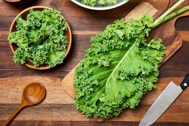 concetto di cavolo fresco lascia insalata su tavola di legno sullo sfondo. preparare insalata di foglie di cavolo nero