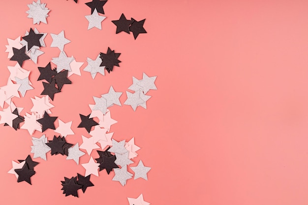 Concetto di celebrazione confetti a forma di stelle su sfondo rosa vista superiore piatta