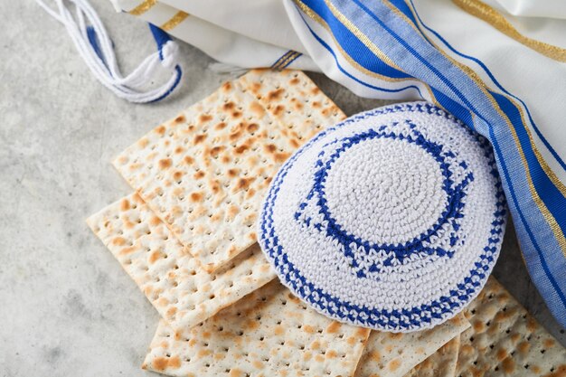 Concetto di celebrazione della Pasqua ebraica Matzah red kosher e noce Rituale tradizionale Pane ebraico matzah kippah e tallit su vecchio sfondo di cemento Cibo pasquale Festa ebraica di Pesach