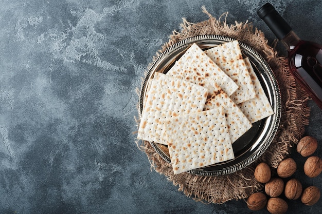 Concetto di celebrazione della Pasqua ebraica Matzah rosso kosher e noce Rituale tradizionale pane ebraico su vecchio sfondo di cemento grigio scuro Cibo pasquale Festa ebraica di Pesach