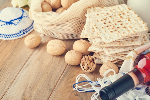 Concetto di celebrazione della Pasqua Matzah rosso kosher e noce Rituale tradizionale Pane ebraico matzah kippah e tallit su sfondo di legno vecchio Cibo pasquale Festa ebraica di Pesach Immagine tonica