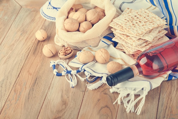 Concetto di celebrazione della Pasqua Matzah rosso kosher e noce Rituale tradizionale Pane ebraico matzah kippah e tallit su sfondo di legno vecchio Cibo pasquale Festa ebraica di Pesach Immagine tonica