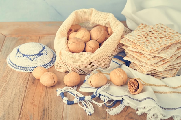 Concetto di celebrazione della Pasqua Matzah rosso kosher e noce Rituale tradizionale Pane ebraico matzah kippah e tallit su sfondo di legno vecchio Cibo pasquale Festa ebraica di Pesach Immagine tonica