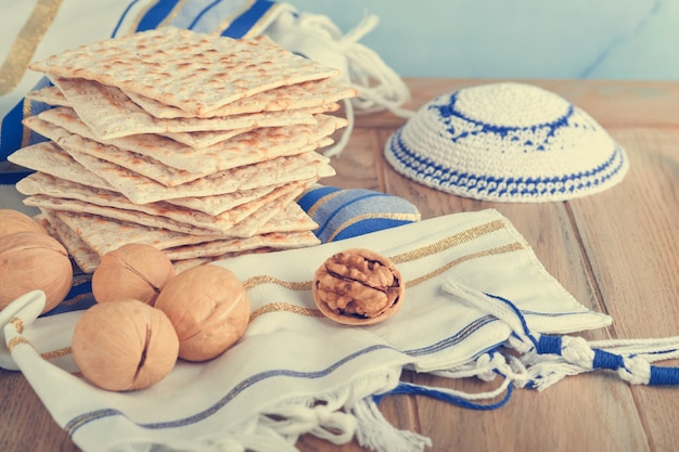 Concetto di celebrazione della Pasqua Matzah rosso kosher e noce Rituale tradizionale Pane ebraico matzah kippah e tallit su sfondo di legno vecchio Cibo pasquale Festa ebraica di Pesach Immagine tonica