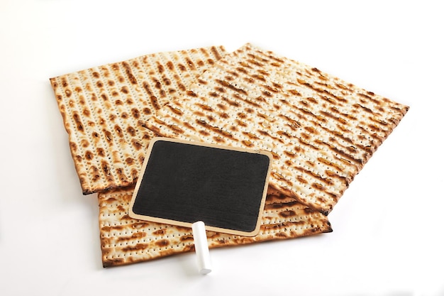 Concetto di celebrazione di Pesach Festa ebraica Pesach Tre matzah quadrati giacciono insieme isolati su sfondo bianco Lavagna nera con spazio di copia per il testo