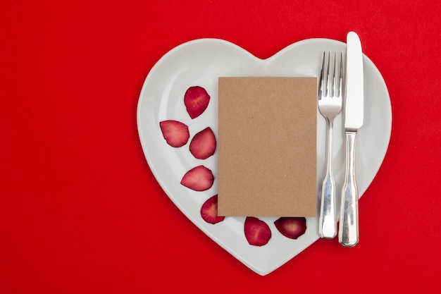 Concetto di cena di San Valentino Piatto a forma di cuore con una scheda vuota