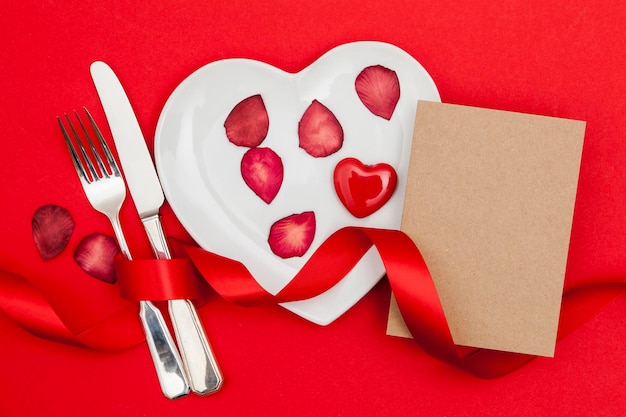 Concetto di cena di San Valentino Piatto a forma di cuore con una scheda vuota
