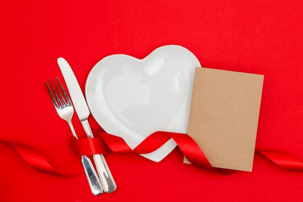 Concetto di cena di San Valentino Piatto a forma di cuore con una scheda vuota