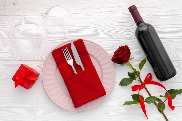 Concetto di cena romantica Regolazione della tabella di San Valentino romantico con vino, bicchieri e scatola rossa