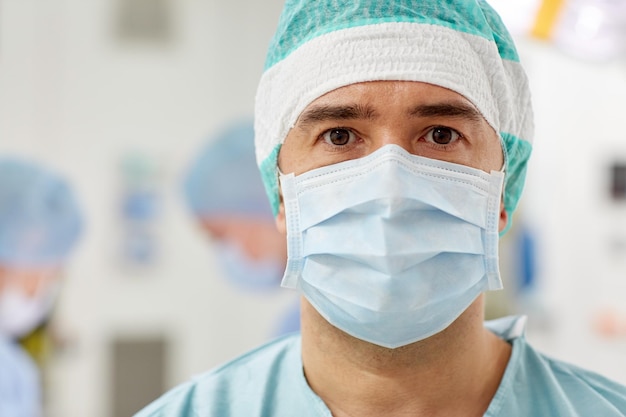 concetto di chirurgia, medicina e persone - chirurgo in sala operatoria con maschera in ospedale