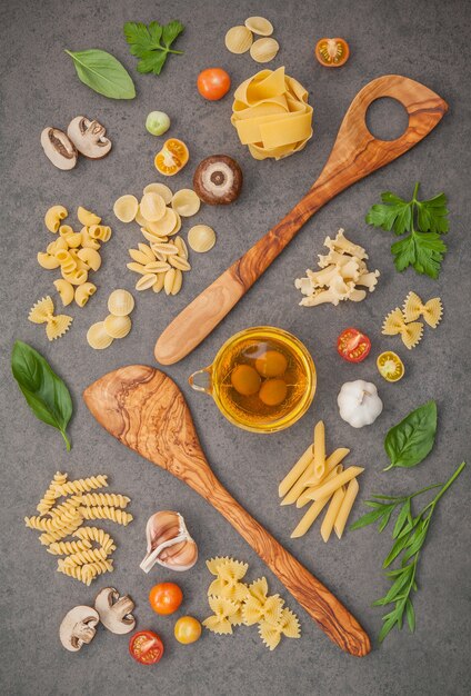 Concetto di cibi italiani e menu design. Pasta con ingredienti su fondo in pietra