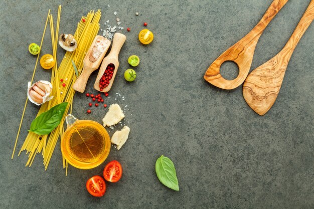 Concetto di cibi italiani e menu design. Pasta con ingredienti su fondo in pietra.