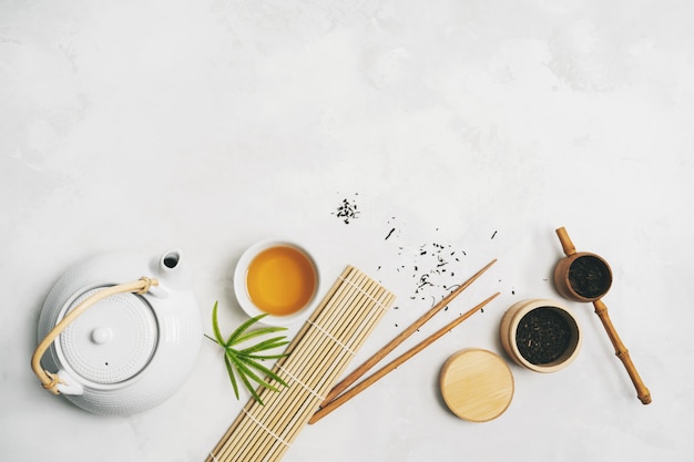 Concetto di cibo asiatico con set da tè, bacchette, stuoia di bambù