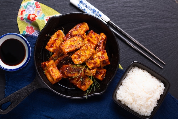 Concetto di cibo asiatico sano In casa mescola salsa di peperoncino piccante fritto, tofu biologico in padella di ferro padella con spazio di copia