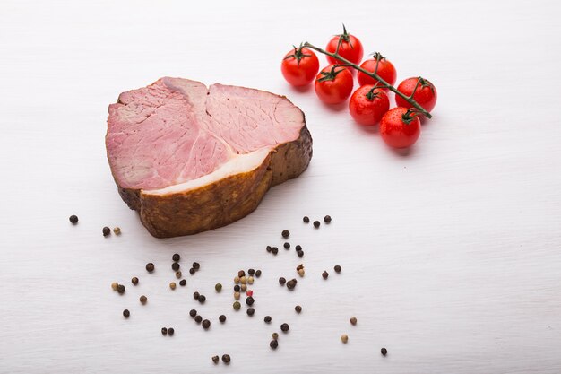 Concetto di cibo, cucina e carne di cavallo - Primo piano di deliziosa carne di cavallo con pepe e pomodori, vista dall'alto.