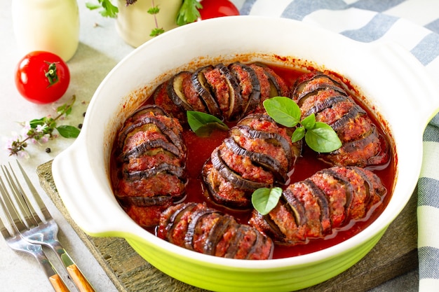 Concetto di cibo del giorno del ringraziamento. Melanzane al forno fatte in casa ripiene di carne di tacchino in salsa di pomodoro su tavola di pietra.