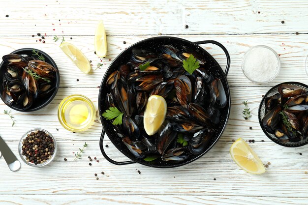 Concetto di cibo delizioso con cozze su un tavolo di legno bianco