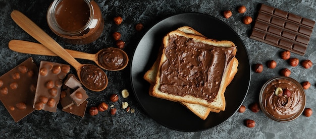 Concetto di cibo delizioso con pasta di cioccolato su sfondo nero affumicato