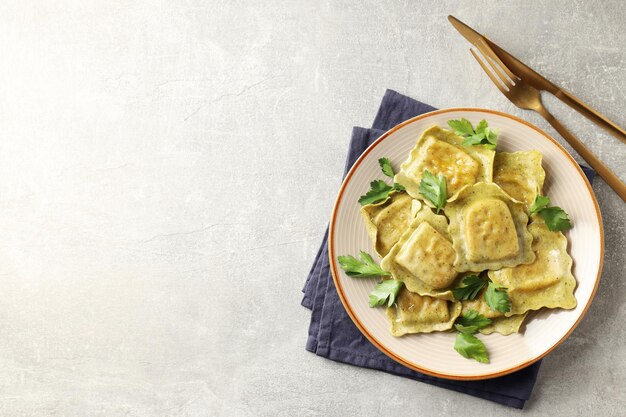 Concetto di cibo delizioso con ravioli su sfondo grigio