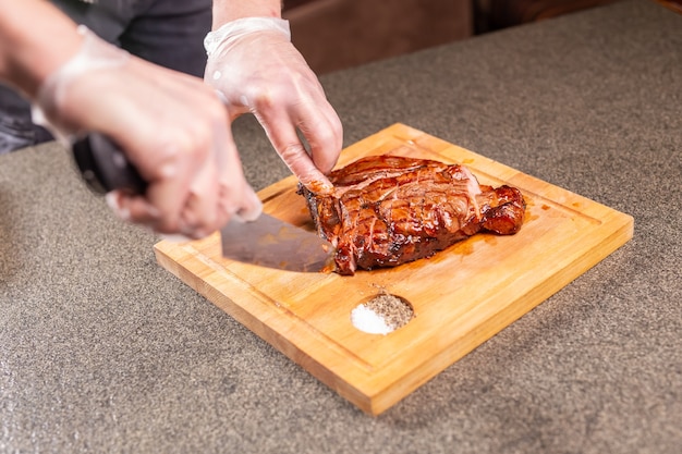 Concetto di cibo, delizioso e artigianale - uomo che taglia bistecca di carne di cavallo.