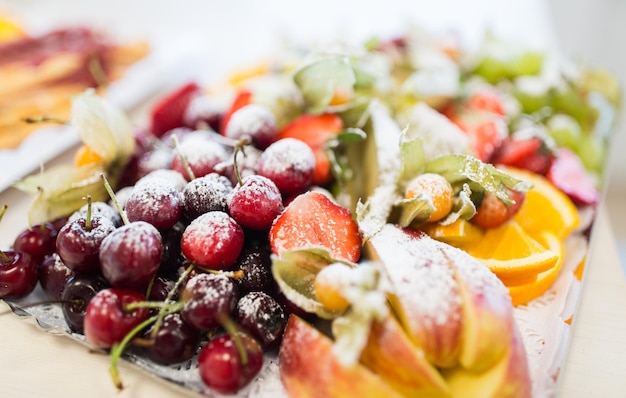 concetto di cibo, dolci e vacanze - primo piano del piatto con dessert di frutta zuccherata