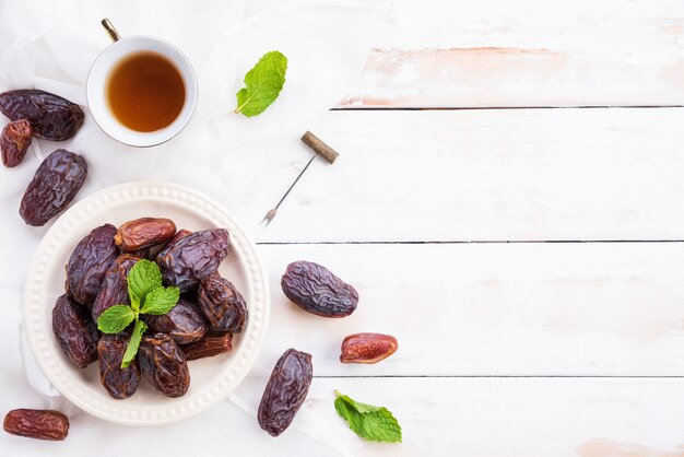 Concetto di cibo e bevande del Ramadan. Tè con date di frutta e foglie di menta