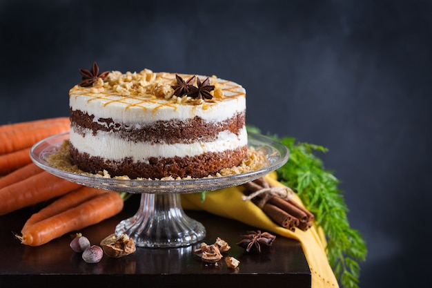 Concetto di cibo e bevande. Torta di carote fatta in casa sana con noci, noci e spezie su un tavolo da cucina rustico. dolce pasquale