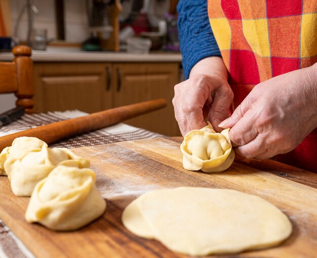 Concetto di cibo fatto in casa. Donna che fa manti con carne di manzo macinata